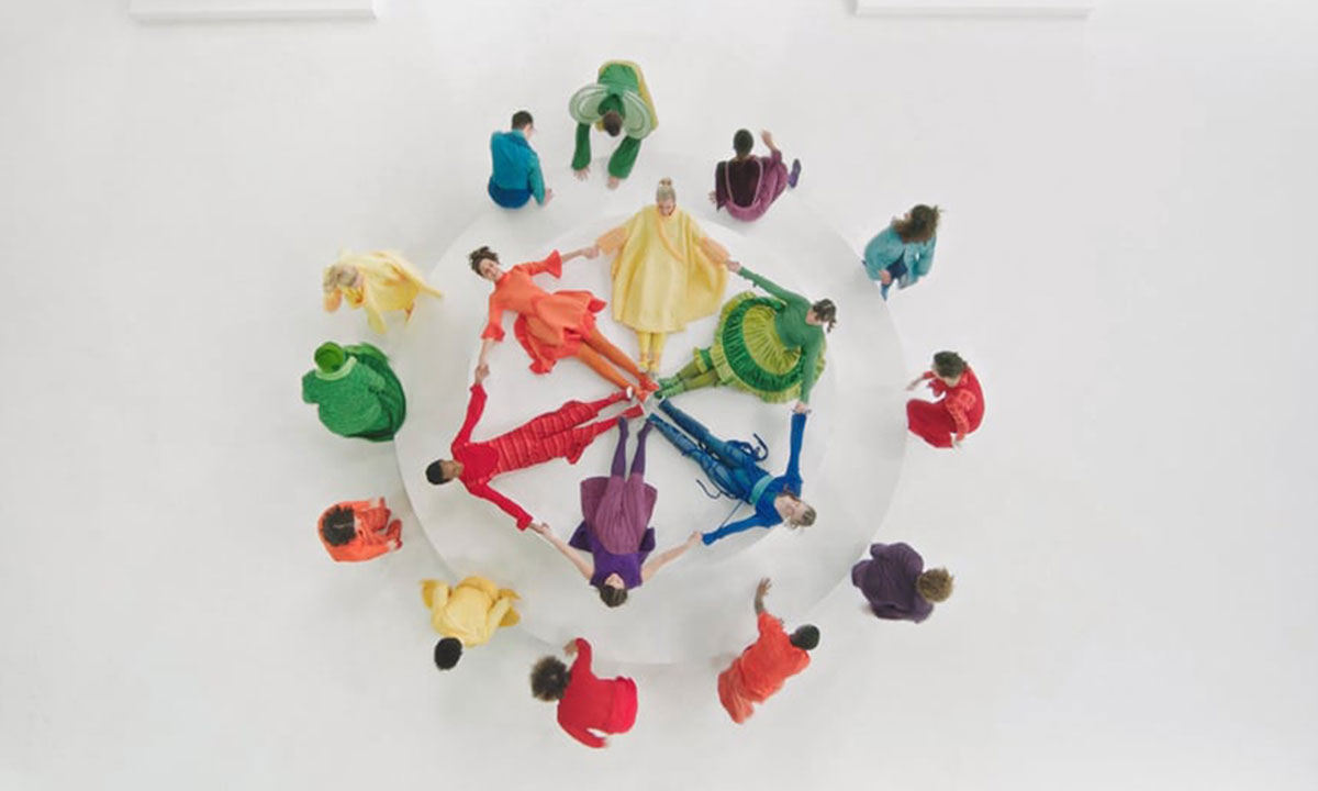 birds eye view of a colorful cast of actors on a pure white stage