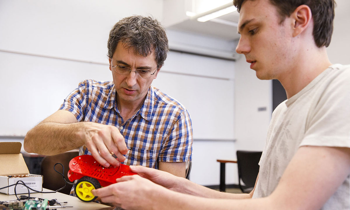 instructor and student working with electronic car