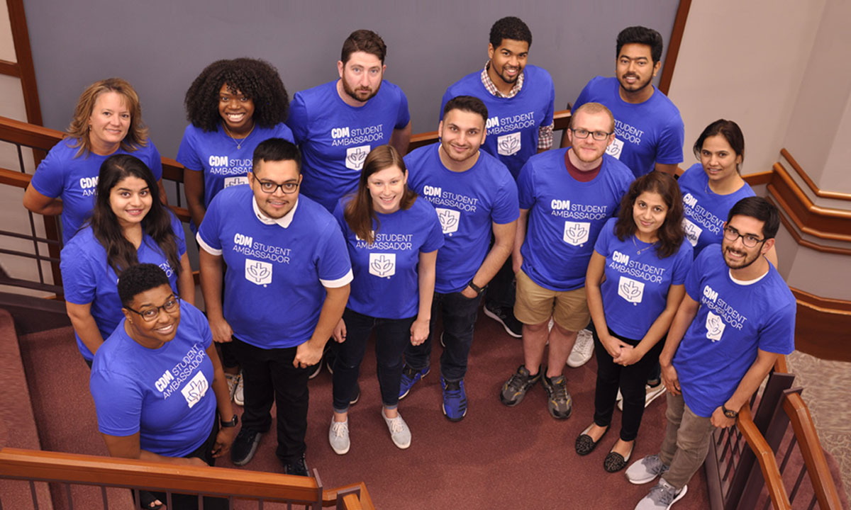 students posing for pic all wearing blue shirts