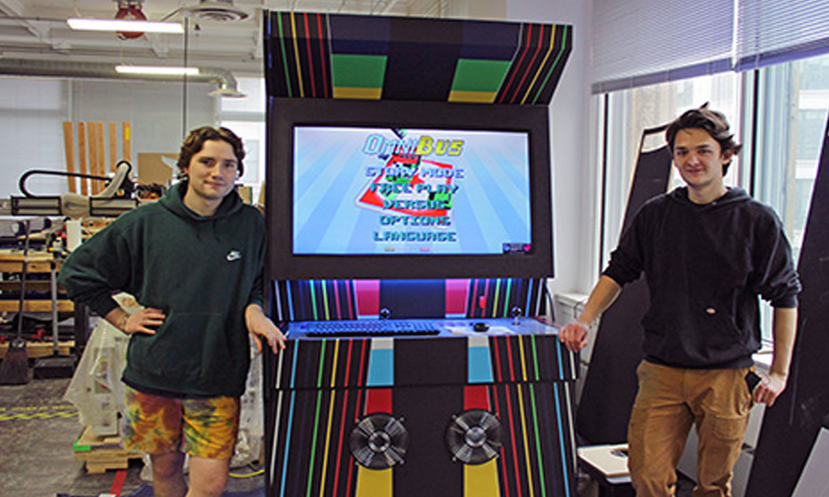 two students infront of a custom arcade game