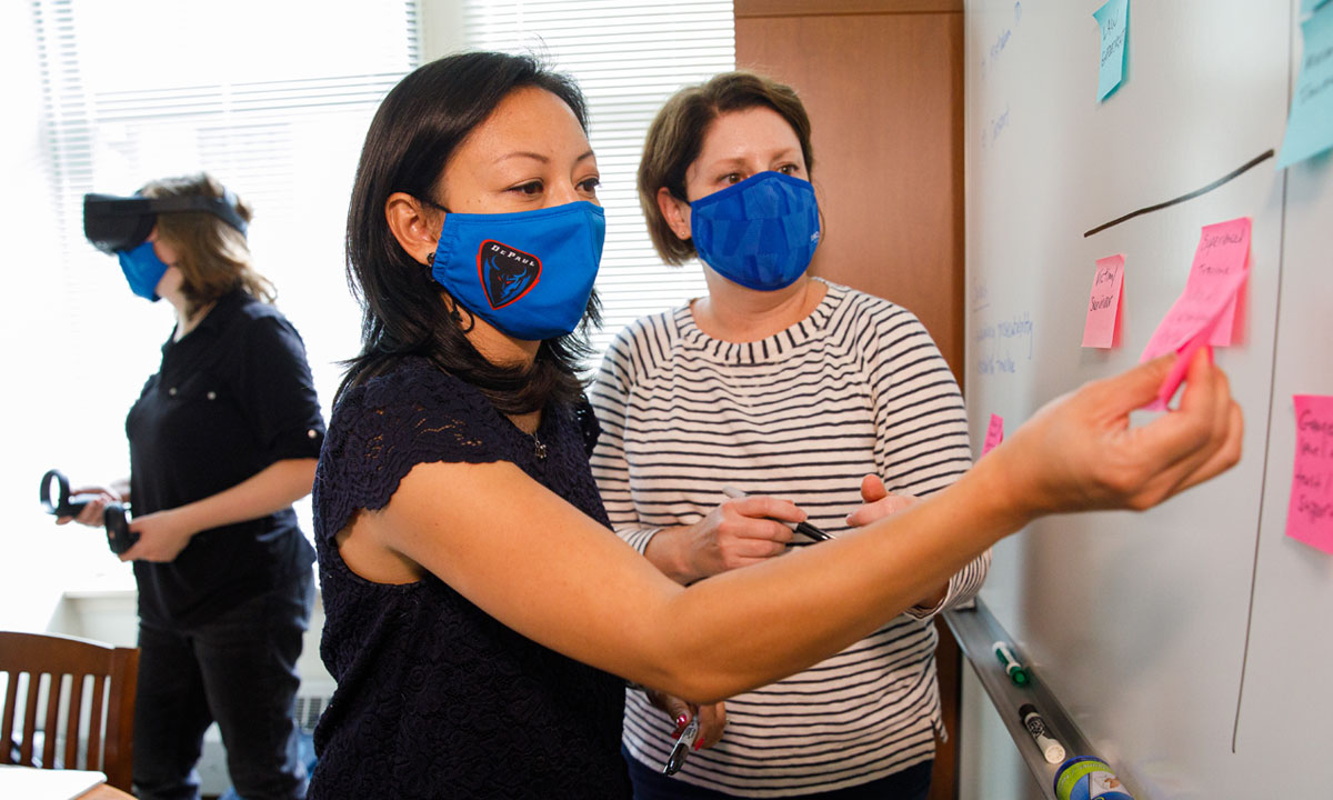  brainstorming with someone playing with a VR headset in the background