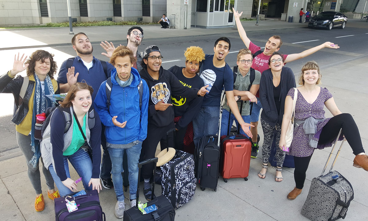 group of DePaul students doing funny poses with their luggage